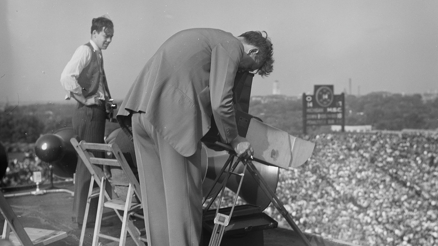 Photographers taking pictures of a U-M football game from the top of Michigan Stadium.